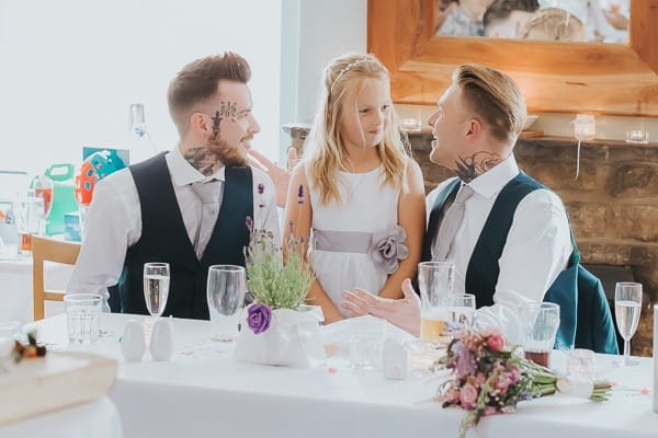 Groom and best man with flower girl