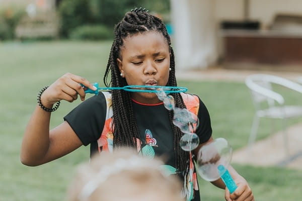 Girl blowing bubbles with bubble wand