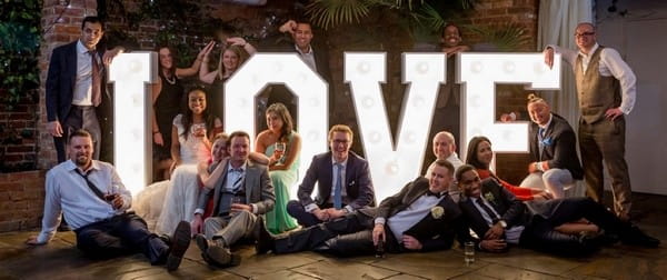 Wedding guests around large illuminated LOVE letters