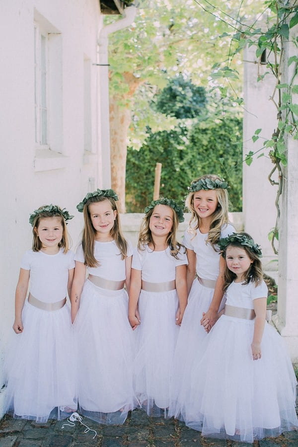 Flower girls in white dresses with floral crowns