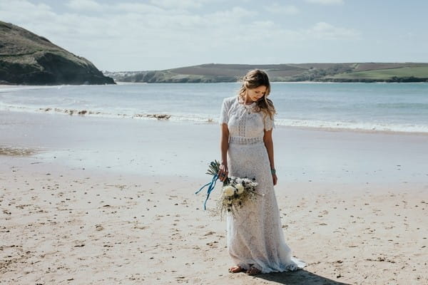 Bride on beach looking down