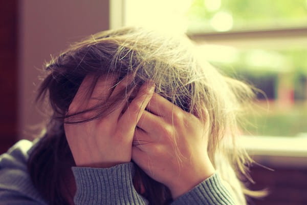 Stressed Woman with Head in Hands