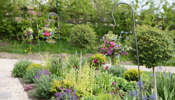 Jars of flowers hanging in garden