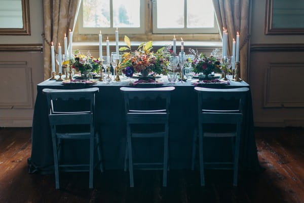 Wedding table with dark tablecloth and chairs