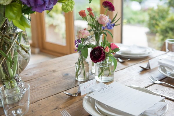 Small vases of flowers at place setting