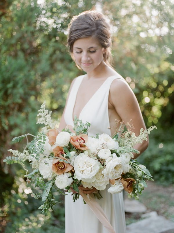 Bride holding bouquet of peach and white flowers
