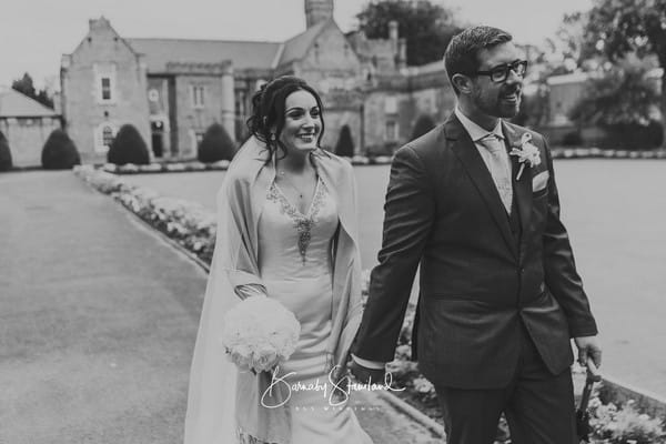 Bride and groom holding hands as they walk down driveway of wedding venue - Picture by BGS Weddings