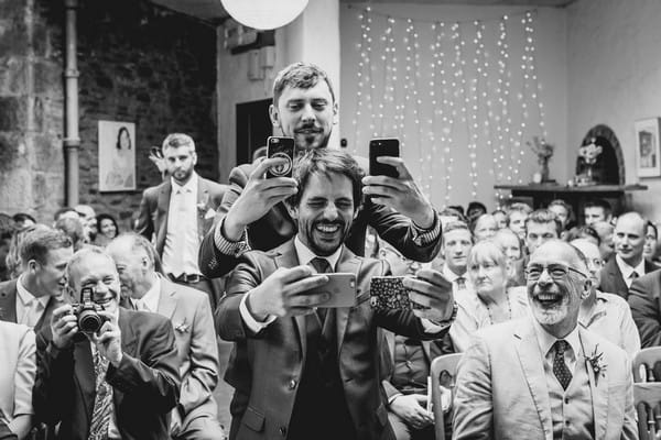 Groom and best man taking selfies at wedding ceremony - Picture by Alexa Poppe Wedding Photography