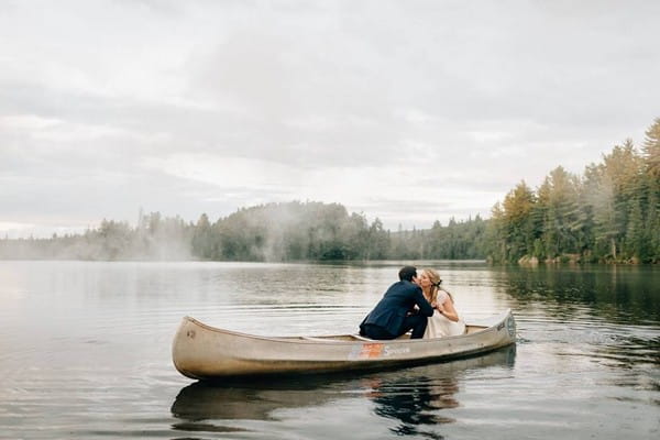 Bride and groom kissing on rowing boat on lake - Picture by Sara Monika Photographer