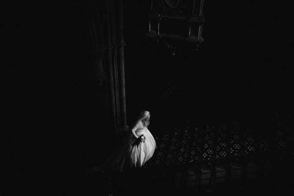 Very dark picture of bride walking up stairs in wedding venue - Picture by The Gibsons