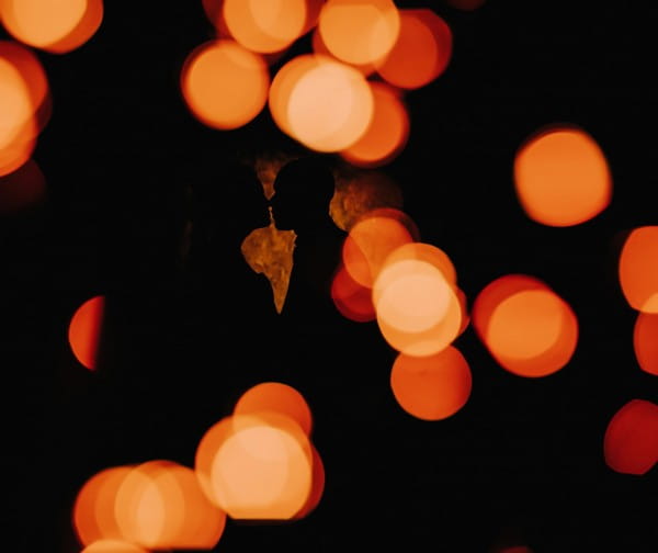 Silhouette of couple about to kiss behind spots of light - Picture by Michelle Wileman Photography