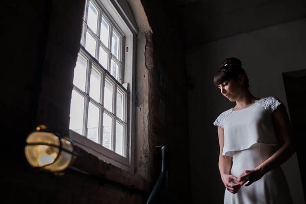 Bride standing by a window - Picture by Simon Dewey Photography