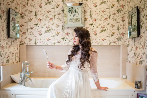 Bride sitting on edge of bath looking in mirror - Picture by S2 Images