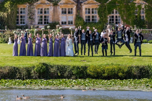 Wedding party by pond at Brympton House