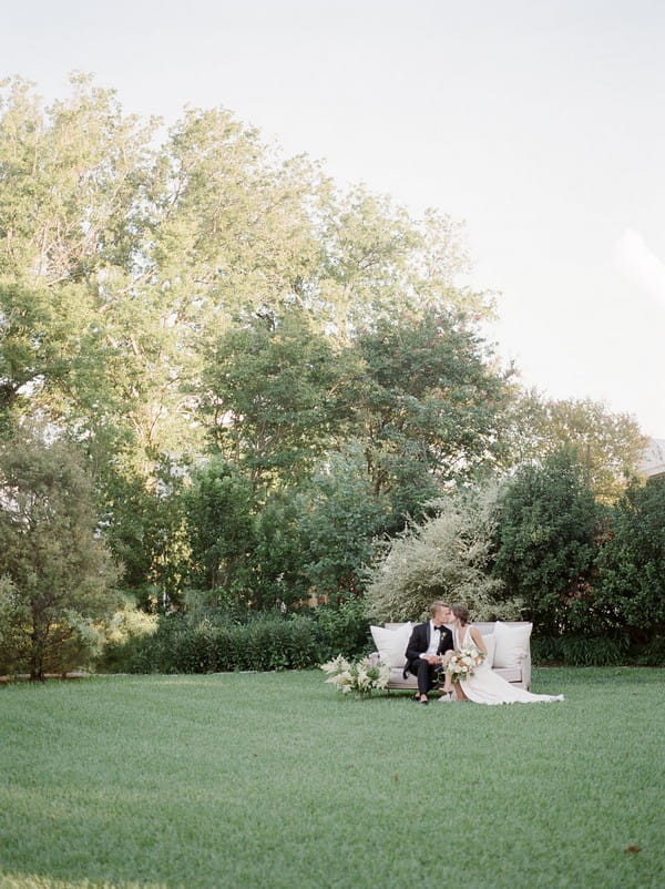 Bride and groom sitting in garden of Barr Mansion in Austin, Texas