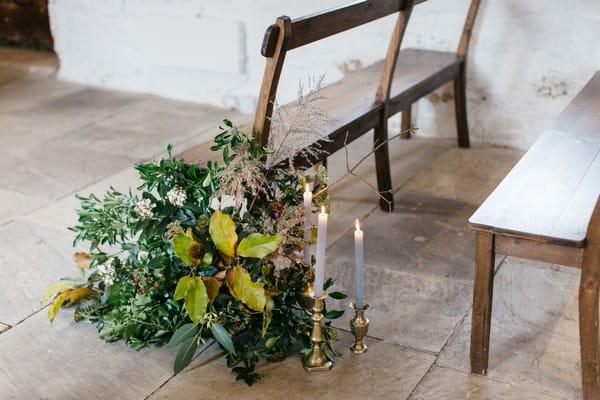 Foliage and candles by wedding ceremony chairs