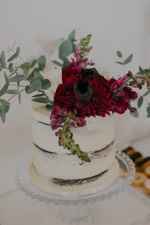 Wedding cake with large red floral topper
