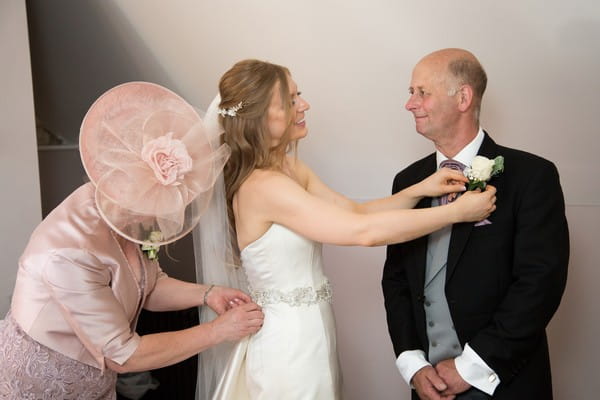 Bride adjusting father's buttonhole