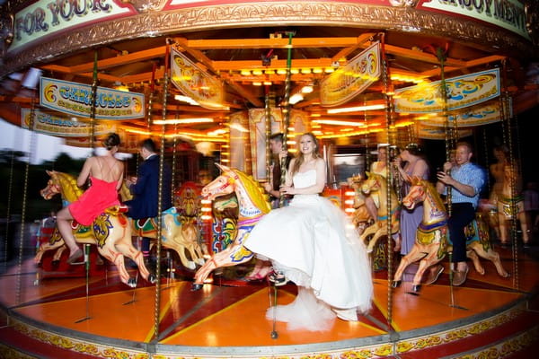 Bride on funfair carousel at Brympton House