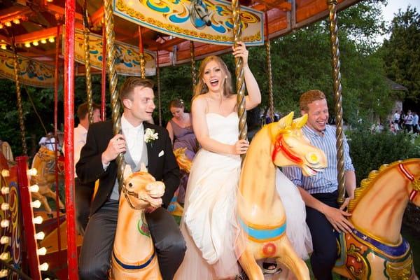 Bride and groom on funfair carousel at Brympton House