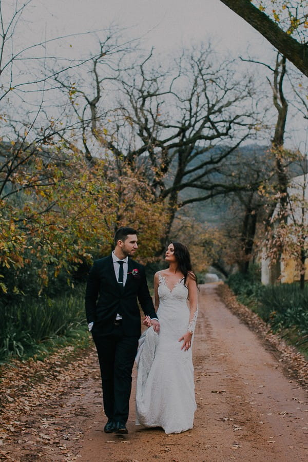 Bride and groom walking through Vondeling vineyard