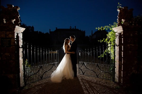 Bride and groom by Brympton House gates at night