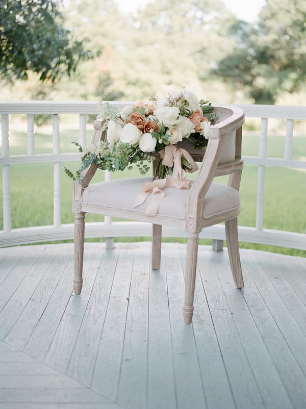 Peach and white bridal bouquet on chair