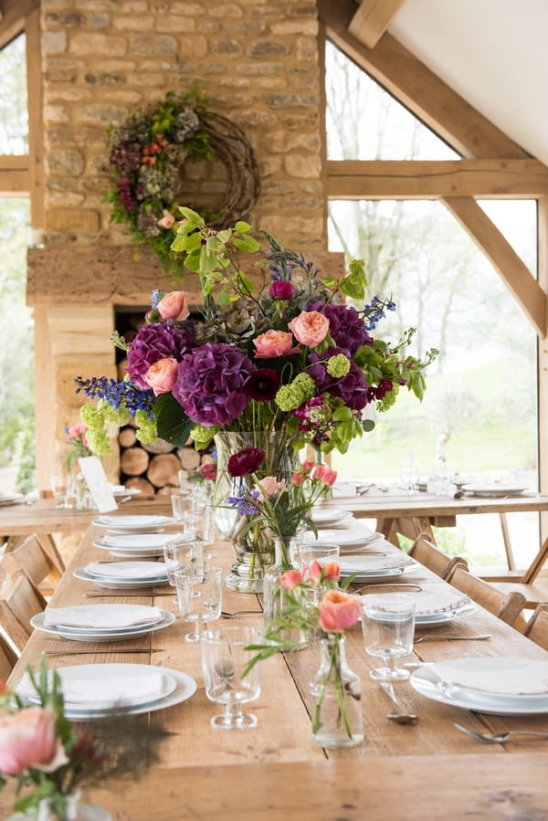 Large display of homegrown flowers on rustic wedding table