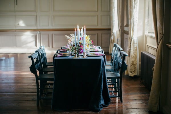 Wedding table with dark tablecloth and styling