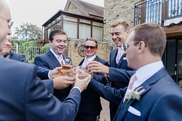 Groomsmen having a drink before wedding