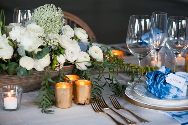 Votives, flowers and gold details on wedding table