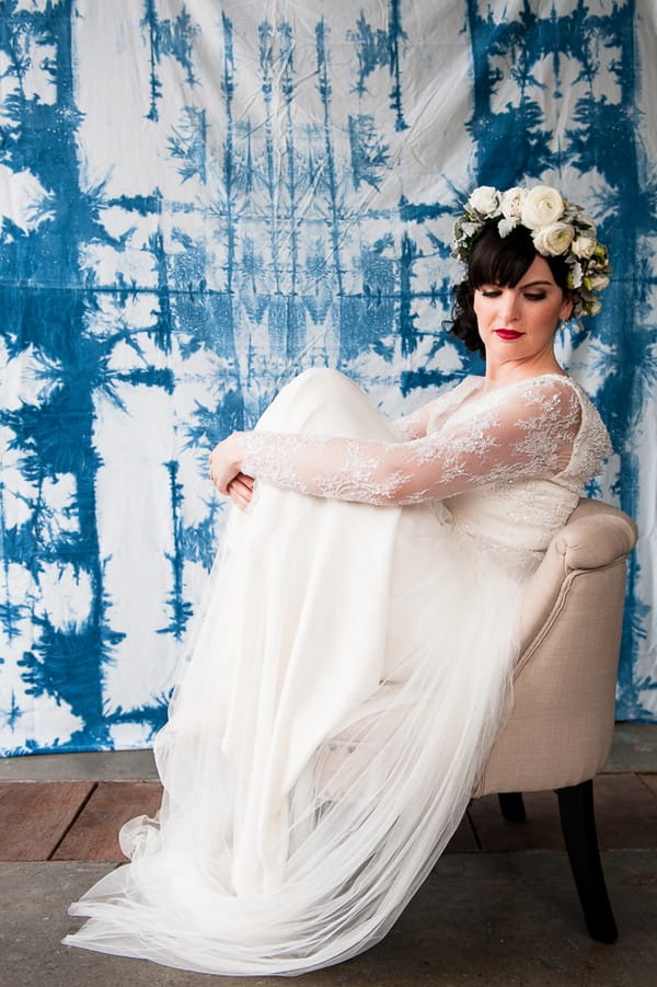 Bride sitting on chair with knees pulled up to her chest