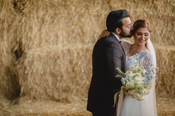 Groom kissing bride on side of the head