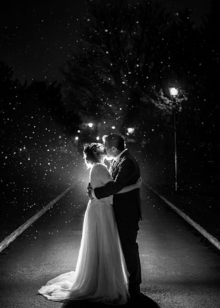 Bride and groom kissing in dark with light catching rain as it falls - Picture by A D Photography