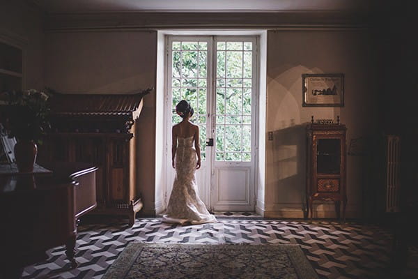 Bride standing looking out of window in door - Picture by Rik Pennington Photography