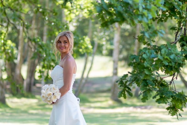Bride under tree looking over her shoulder - Picture by Leanne Ashcroft Photography