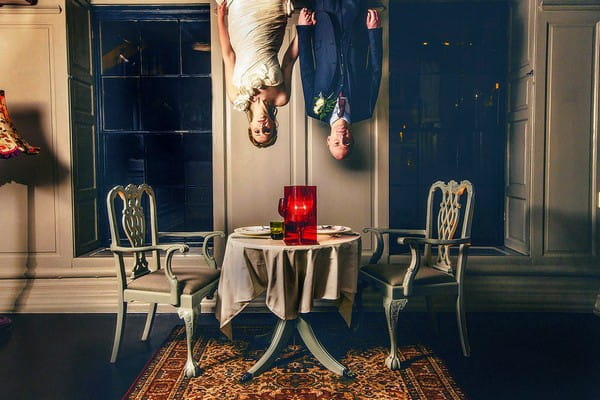 Bride and groom hanging from ceiling above dining table - Picture by Steven Rooney Photography