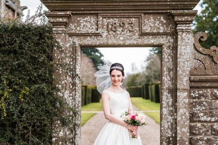 Bride standing in front of doorway in wall at Glamis Castle - Picture by Ally Stuart Photography