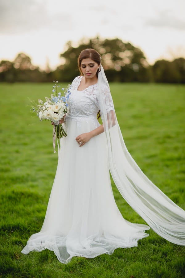 Bride wearing white wedding dress with long veil