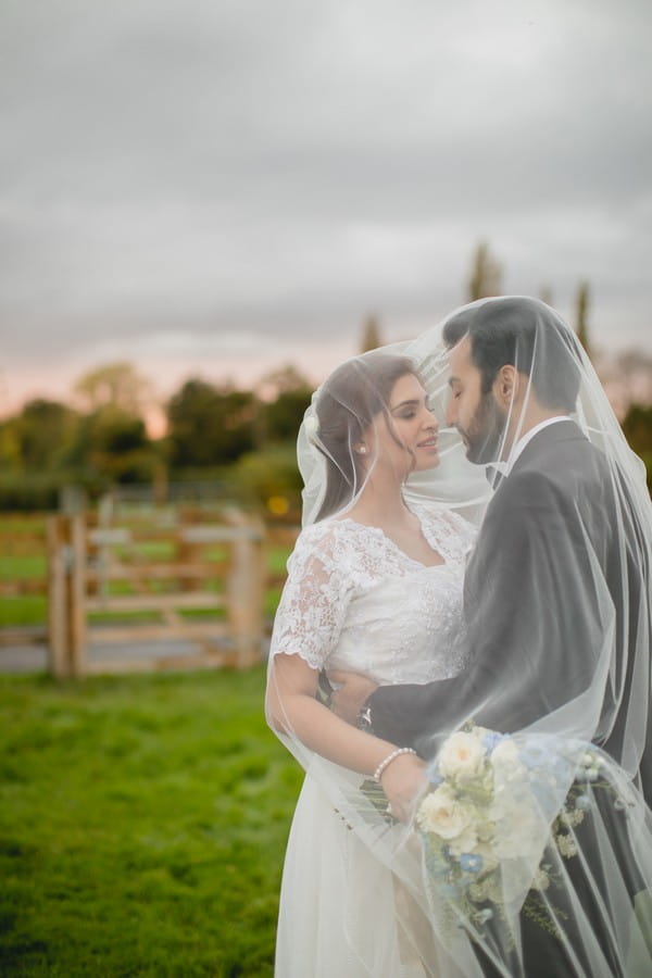 Bride and groom under bride's veil