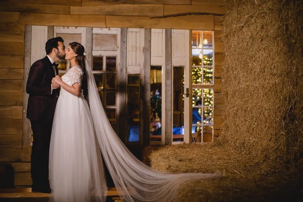 Bride and groom at hay stack at Owen House Wedding Barn