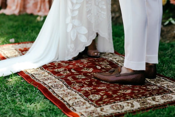 Bride and groom standing on rug during wedding ceremony
