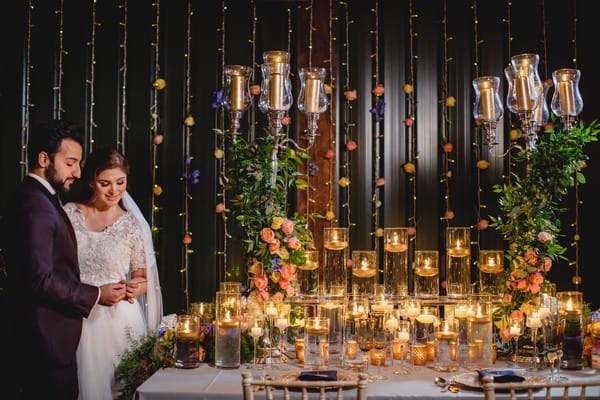 Bride and groom next to table covered in candles