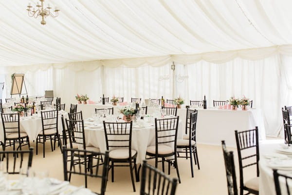 Wedding table with black chairs in marquee