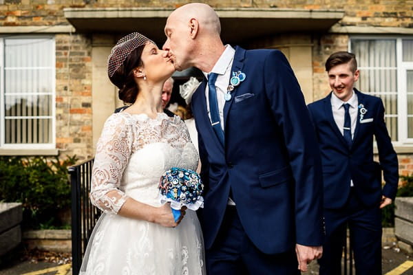 Bride and groom kissing outside registry office