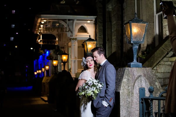 1920s bride and groom outside The Duke of Cornwall Hotel at night