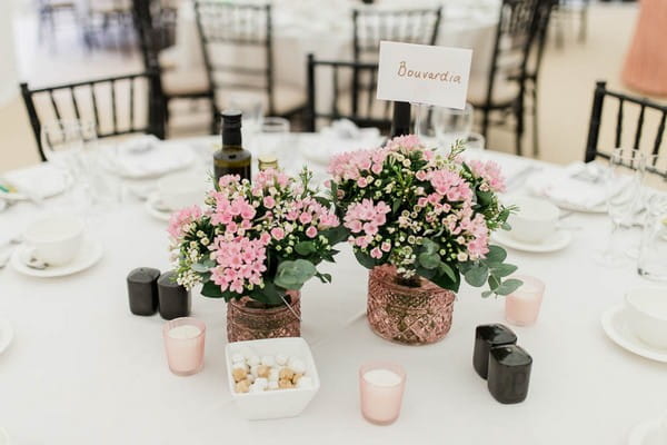 Pink flowers in copper pots on wedding table