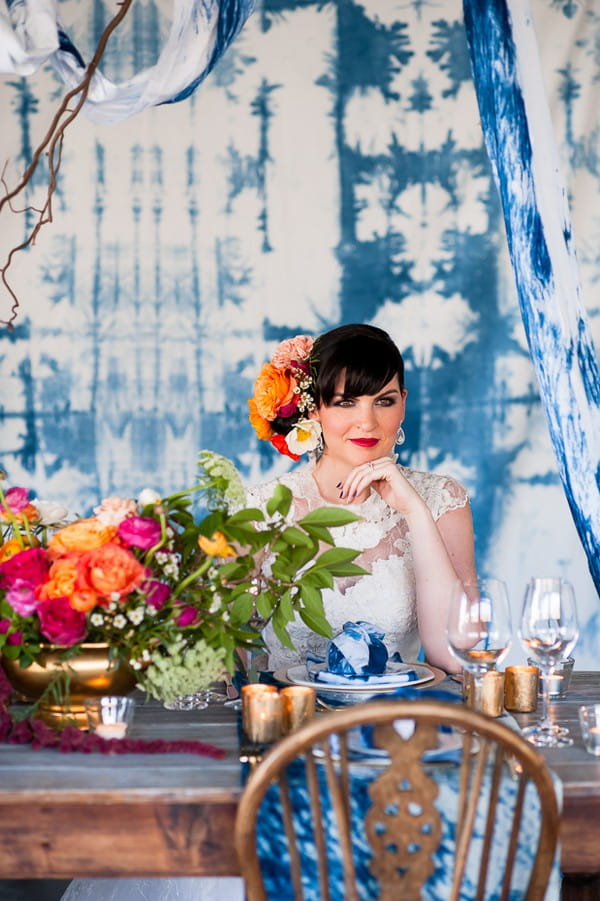 Bride sitting at wedding table with indigo Shibori backdrop