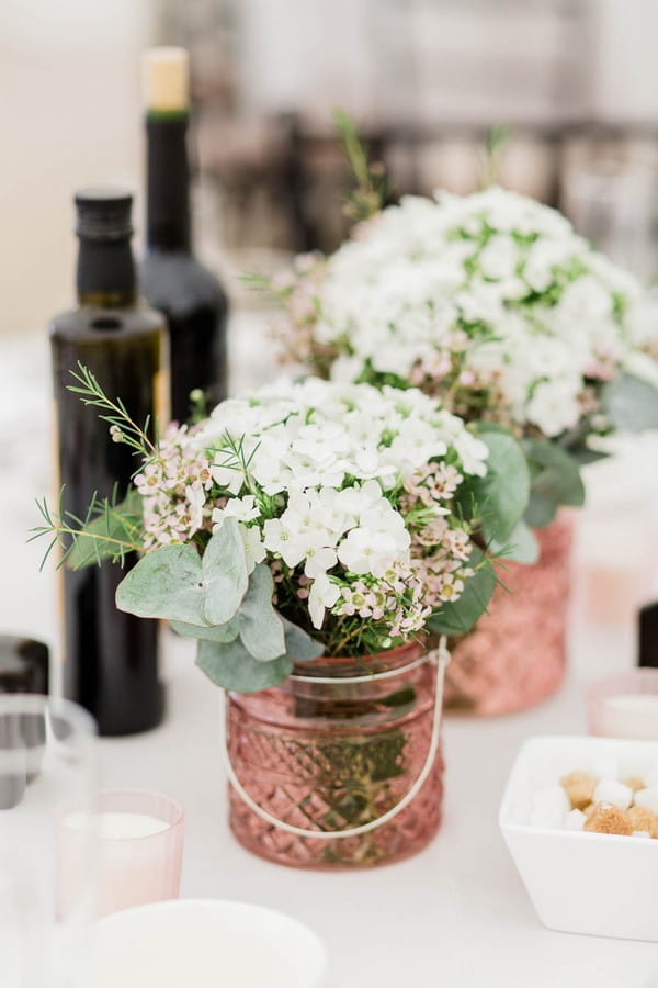White flowers in copper pots on wedding table