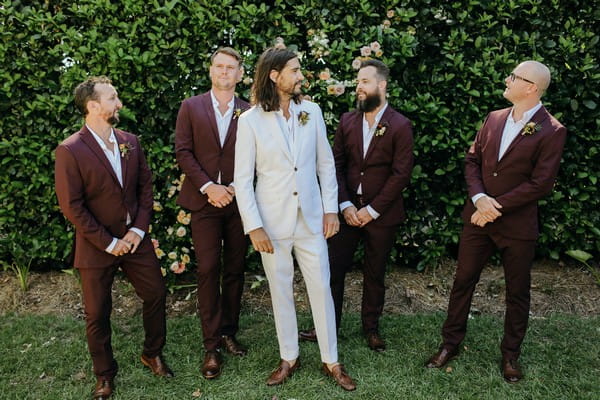 Groom with groomsmen in burgundy suits